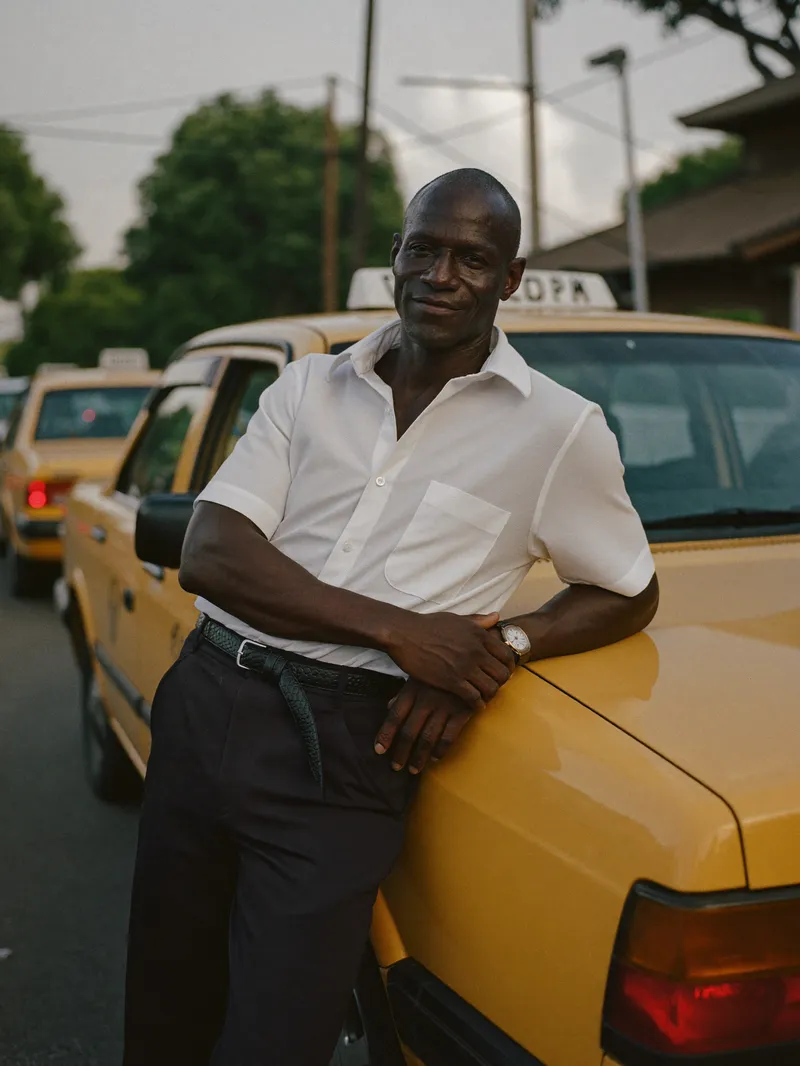 Un propriétaire de taxis appuyé contre son véhicule.