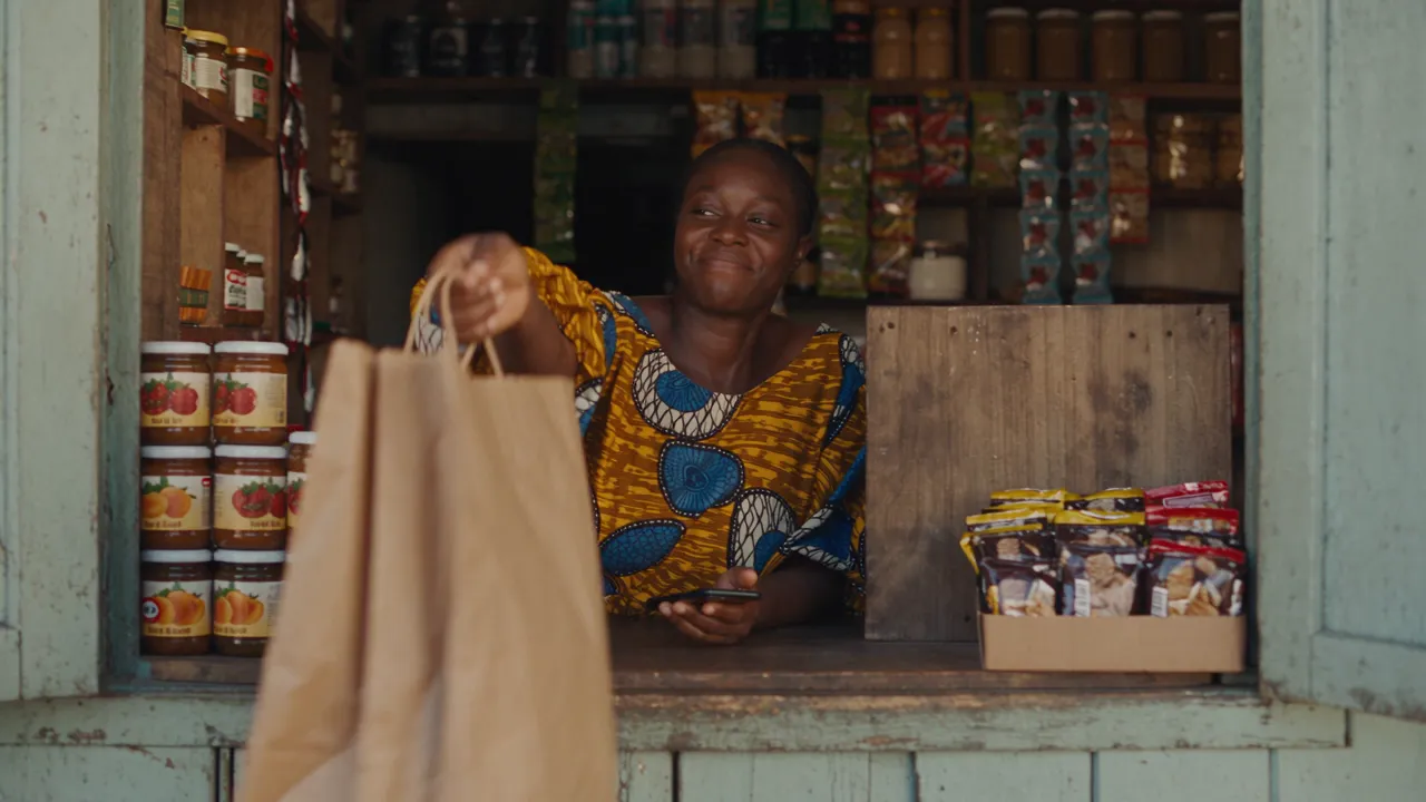 Une commerçante d'Abidjan enregistre une vente sur son téléphone dans sa boutique.